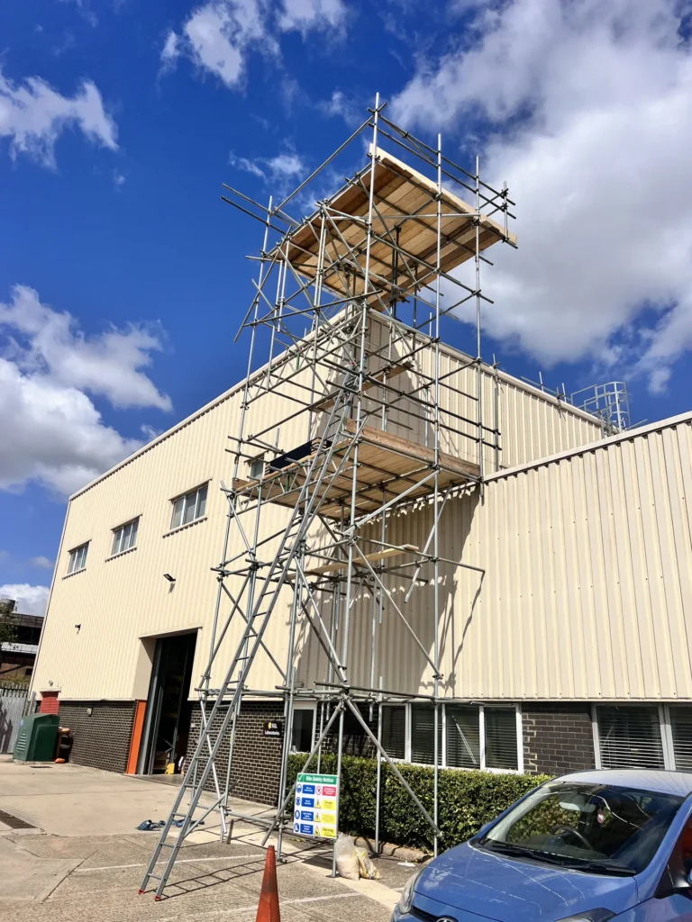 Scaffold tower beside an industrial building
